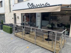 a row of chairs sitting outside of a restaurant at Manna Aparthotel in Jászberény