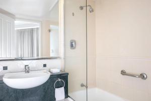 a bathroom with a tub, sink, and shower at Mantra Legends Hotel in Gold Coast