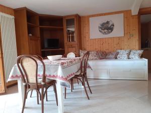 a dining room with a table and chairs and a couch at L'angolo di Anna in Porretta Terme