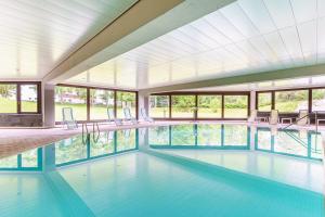 a large swimming pool with chairs and windows at Appartement Seefeld Tirol - Luxusappartement Birkenwald in Seefeld in Tirol