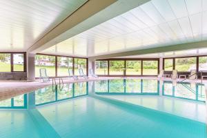 duży basen z krzesłami i oknami w obiekcie Appartement Seefeld Tirol - Luxusappartement Birkenwald w mieście Seefeld in Tirol