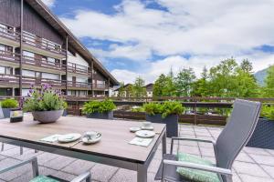 eine Terrasse mit einem Tisch und Stühlen auf dem Balkon in der Unterkunft Appartement Seefeld Tirol - Luxusappartement Birkenwald in Seefeld in Tirol