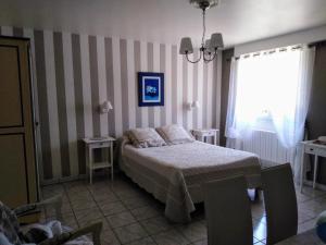 a bedroom with a bed and two tables and a window at La Touille in Cénac-et-Saint-Julien