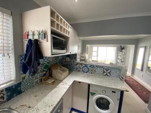 a small kitchen with a washing machine in it at Net Hier in Eersterivierstrand