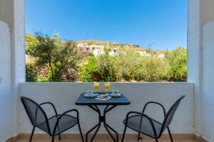 a table with two chairs and drinks on a balcony at Skala Hotel in Skala