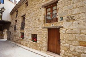 un edificio de piedra con una puerta de madera y una ventana en Casa rural con mucho encanto en un entorno mágico, en Horta de Sant Joan