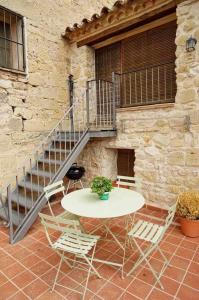 une terrasse avec une table, des chaises et un escalier. dans l'établissement Casa rural con mucho encanto en un entorno mágico, à Horta de San Joan