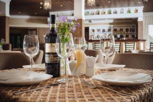 una bottiglia di vino seduta su un tavolo con bicchieri di Welna Eco Spa Resort a Tarusa