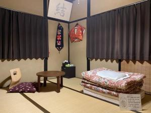 Habitación con cama y mesa. en Kakure-Yado Yuji-inn, en Kurashiki