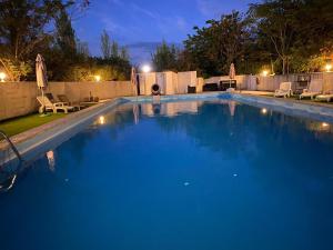 uma grande piscina com água azul à noite em Hotel Carina em Apt