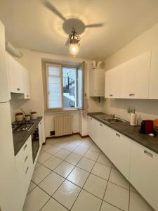 a kitchen with white cabinets and a ceiling fan at Fontana di San Giacomo in Bergamo