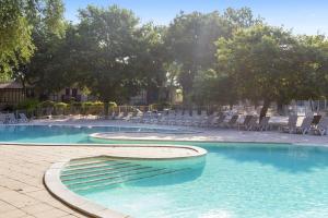 a swimming pool with chairs and chairs in a resort at Village Pierre & Vacances Moliets in Moliets-et-Maa