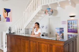 a woman sitting at a counter talking on a cell phone at Madame Vacances Le Domaine de Vertmarines in Saint-Jean-de-Monts +40 photos