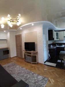 a living room with a television and a kitchen at Трикімнатні Апартаменти центр Волі43 in Luts'k
