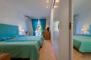 two beds in a room with blue curtains at Skala Hotel in Skala