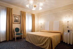 a hotel room with a bed and a chair at Hotel Principe in Venice