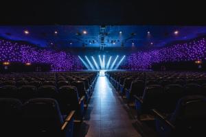 an empty auditorium with purple lights in a theatre at Hotel Cleopatra Palace in Playa de las Americas