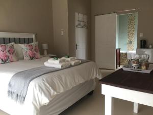 um quarto com uma cama com toalhas em The Vine em Klawer