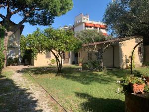 una casa con un patio con árboles y un edificio en Il Pozzetto Home Resort, en Pietrasanta