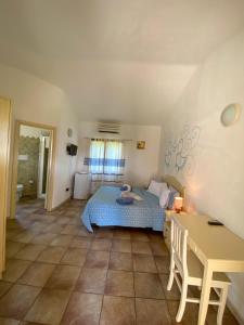 a bedroom with a bed and a table in it at Agriturismo Salmarina in Abbiadori