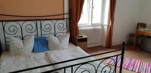 a bedroom with a bed with blue pillows and a window at Forsthaus Merzalben Hostel in Merzalben