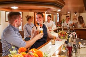 a woman standing at a bar with a bartender at Hotel Lamm in Ostfildern