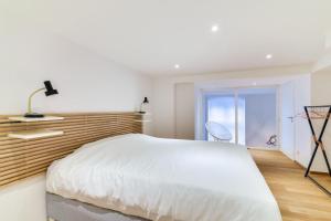 Un dormitorio con una gran cama blanca y una ventana en High Standing Comfortable Loft 125m2 city center en Estrasburgo