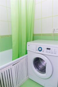 una lavatrice in bagno con tenda verde di Охайна двокімнатна квартира біля Дніпра! a Čerkasy