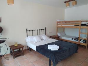 a bedroom with a bed with two bunk beds at Hotel Rural La Marmita de Ahlam in Fondón