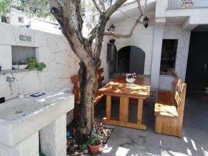 um pátio com uma mesa ao lado de uma árvore em Apartments in Villa TOP TROGIR em Trogir