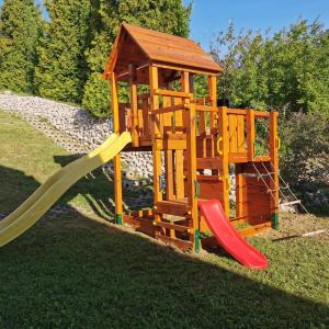um parque infantil de madeira com um escorrega e um gazebo em BRILLWELLNESS em Zalakaros