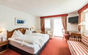 una camera d'albergo con letto e divano di BAD MOOS Dependance "Mühlenhof" a Sesto