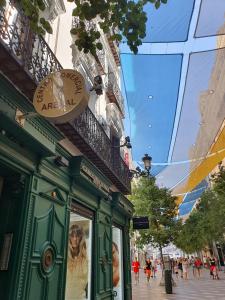 un edificio verde con un reloj en una calle en Aparment Puerta de sol, en Madrid