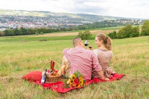 een man en een vrouw zittend op een picknickdeken bij Hotel Lamm in Ostfildern