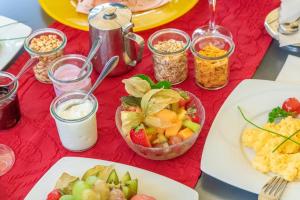einen Tisch mit Teller mit Lebensmitteln auf einem roten Tischtuch in der Unterkunft Hotel Lamm in Ostfildern