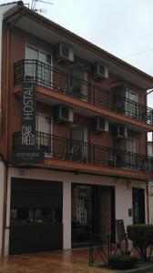 un edificio con balcones en un lateral en Hostal Gastrobar Carmelo, en Villarejo de Salvanés