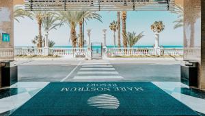 a welcome mat at the entrance to a resort with palm trees at Hotel Cleopatra Palace in Playa de las Americas
