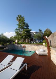una terraza de madera con piscina y una casa en Montjuic Boutique Bed & Breakfast Girona en Girona