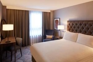 ein Hotelzimmer mit einem Bett, einem Schreibtisch und einem Stuhl in der Unterkunft voco Edinburgh - Haymarket, an IHG Hotel in Edinburgh