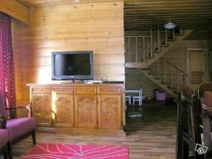 a living room with a television on a dresser with a staircase at Cottage Elsa in Kuopio