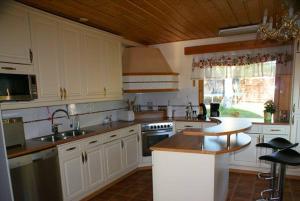 a kitchen with white cabinets and a sink and a counter at Cottage Elsa in Kuopio