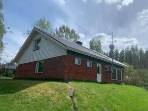 a brick house on top of a grassy hill at Cottage Elsa in Kuopio