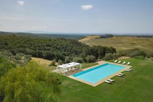 una vista aérea de una piscina en un campo con sillas en La Marrana - Castello del Terriccio, en Castellina Marittima