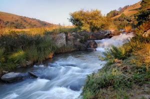 a river with rapids on the side of a mountain at Stonecutters Lodge in Dullstroom
