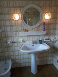 a bathroom with a sink and a mirror and a toilet at Appartamento Mariuccia in Dosoledo