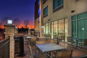 een patio met tafels en stoelen buiten een gebouw bij Holiday Inn Express & Suites - Tulsa Northeast - Owasso, an IHG Hotel in Owasso