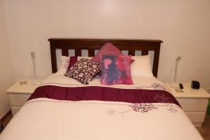 a bed with some pillows on top of it at Waiotahi Valley Lodge in Thames