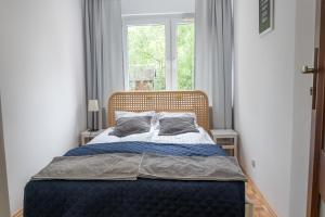 łóżko w sypialni z oknem w obiekcie Nest Comfort Toruń w Toruniu