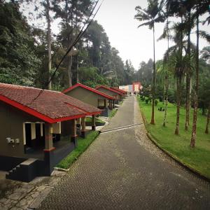 una calle vacía con una fila de casas y palmeras en Surya Hotel & Resort, en Baturraden