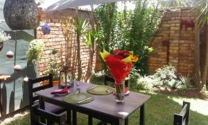 a wooden table with a vase of flowers on it at The Lazy Grape Guest Lodge & Spa in Benoni